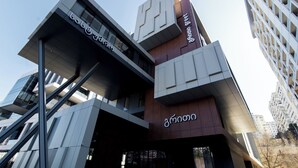 A modern building with a unique architectural design, featuring a mix of glass and wood materials.