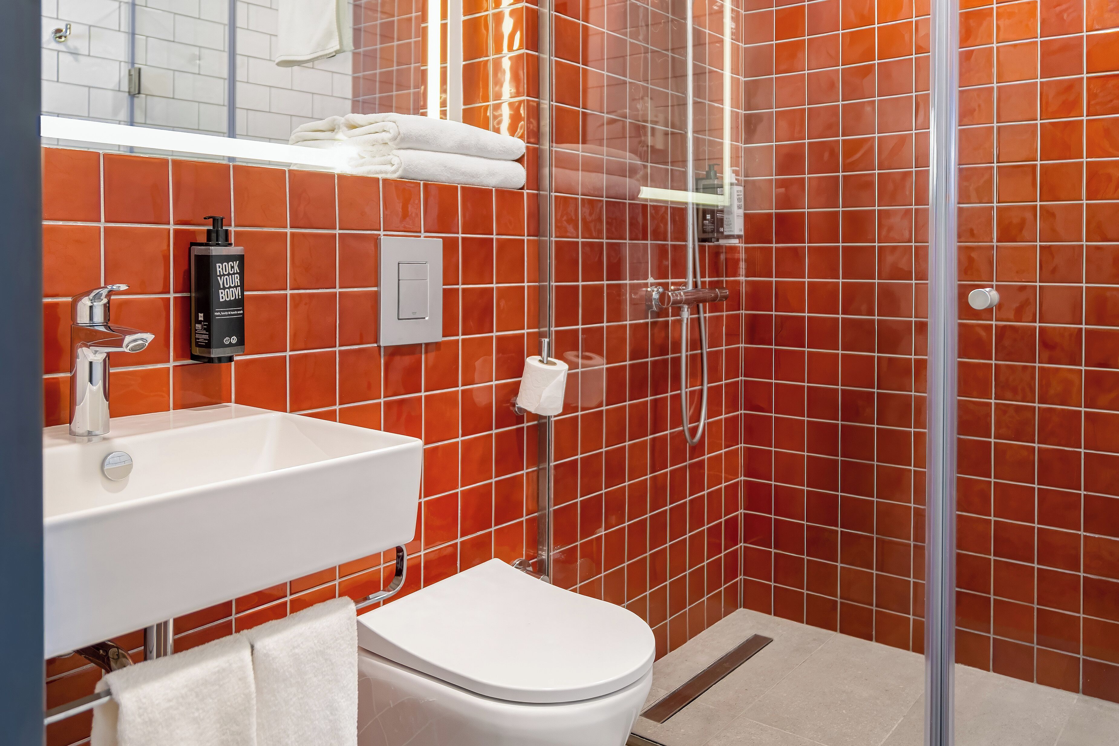 A bathroom with a white sink, a toilet, and a shower area.