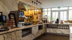 A modern kitchen with marble countertops, a coffee machine, and hanging pendant lights. - Hotel Ter Zand - Handwritten Collection (Burgh-Haamstede)