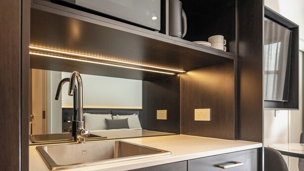 A modern bathroom with a large mirror, a sink, and a vanity with drawers. - Mantra Shepparton (Shepparton)