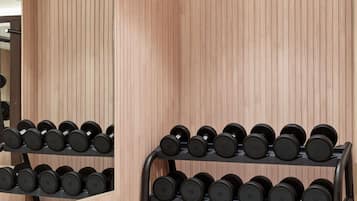 Een spiegelwand met een houten paneelmotief en een zwarte halterrek met gewichten.