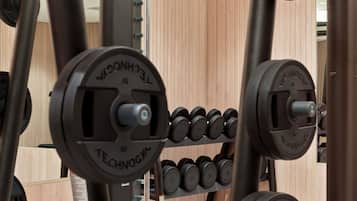 A weightlifting rack with adjustable dumbbells and barbells.