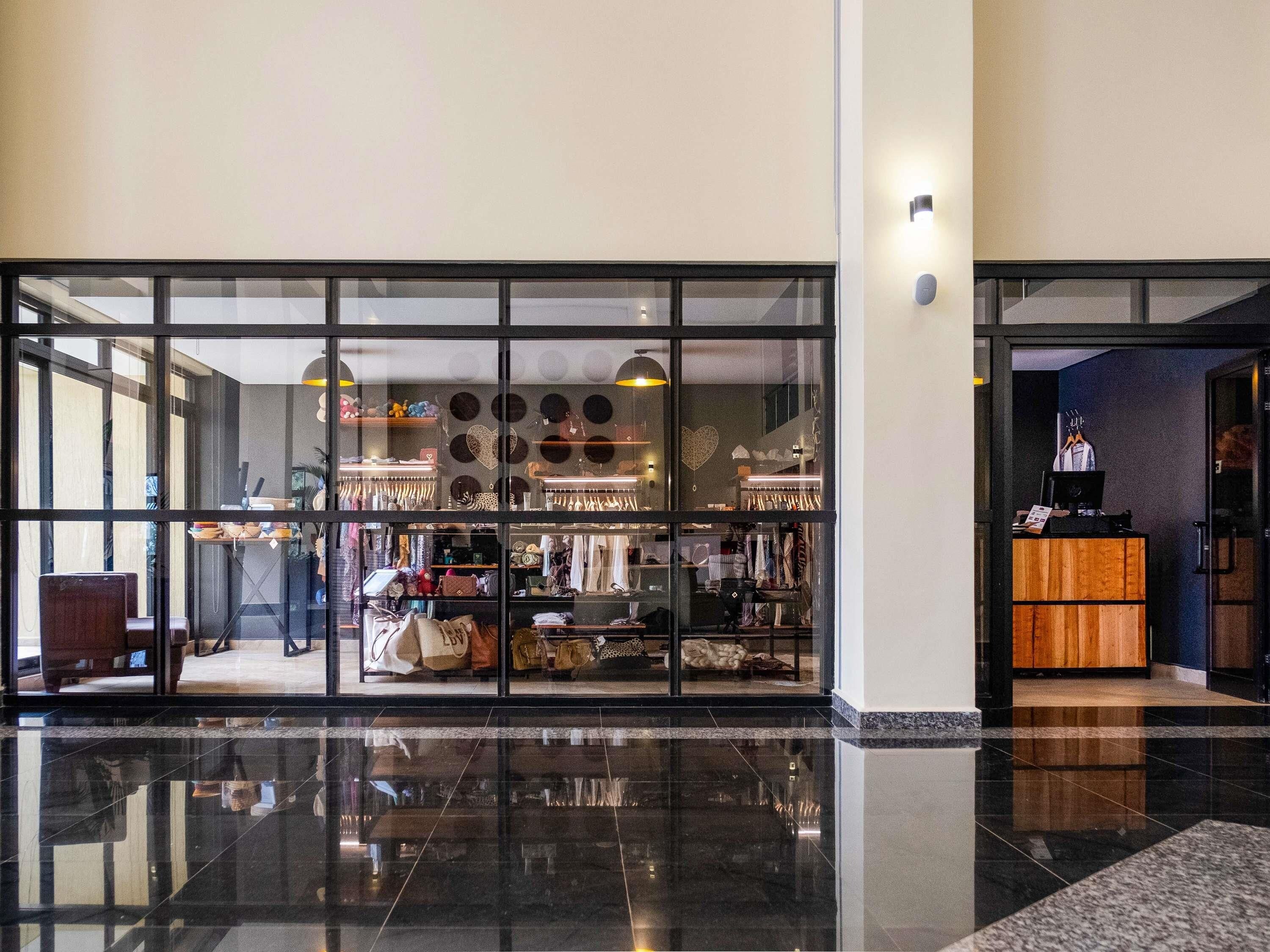 A store with a glass facade, displaying various bags and accessories.