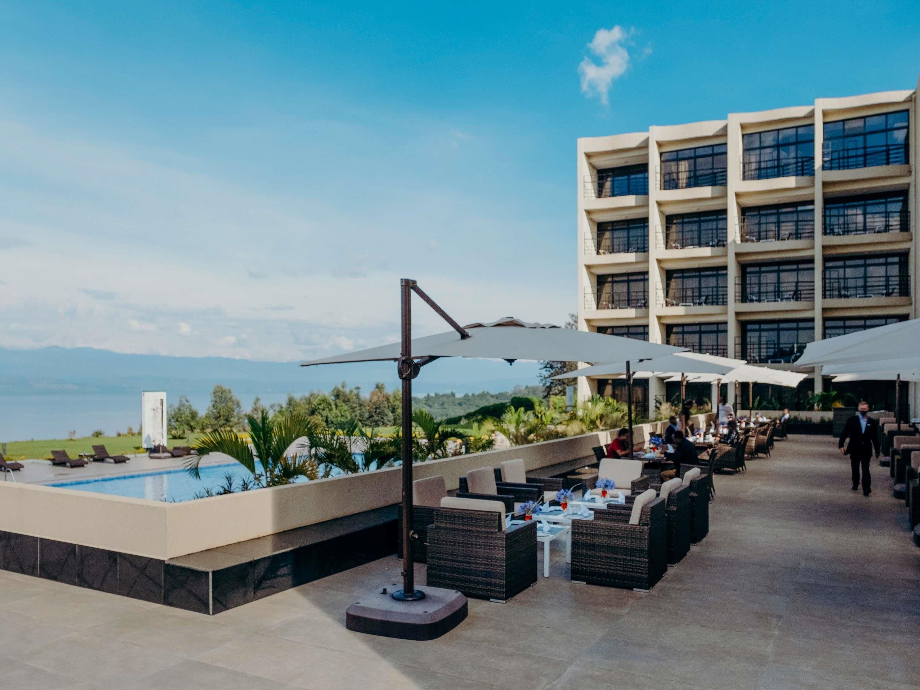 A rooftop pool area with outdoor seating and a view of the sea.