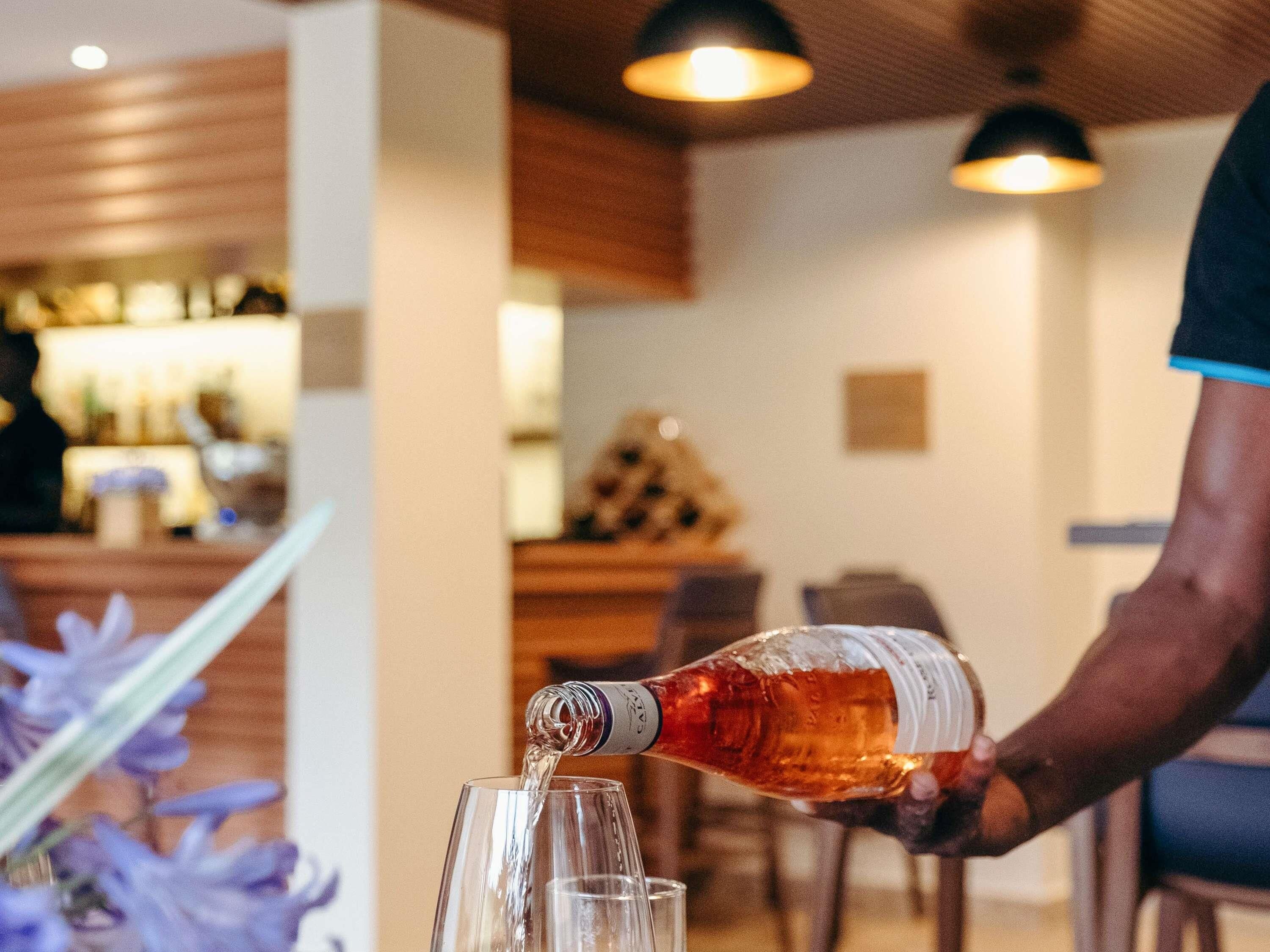 A person pouring a beverage into a glass.