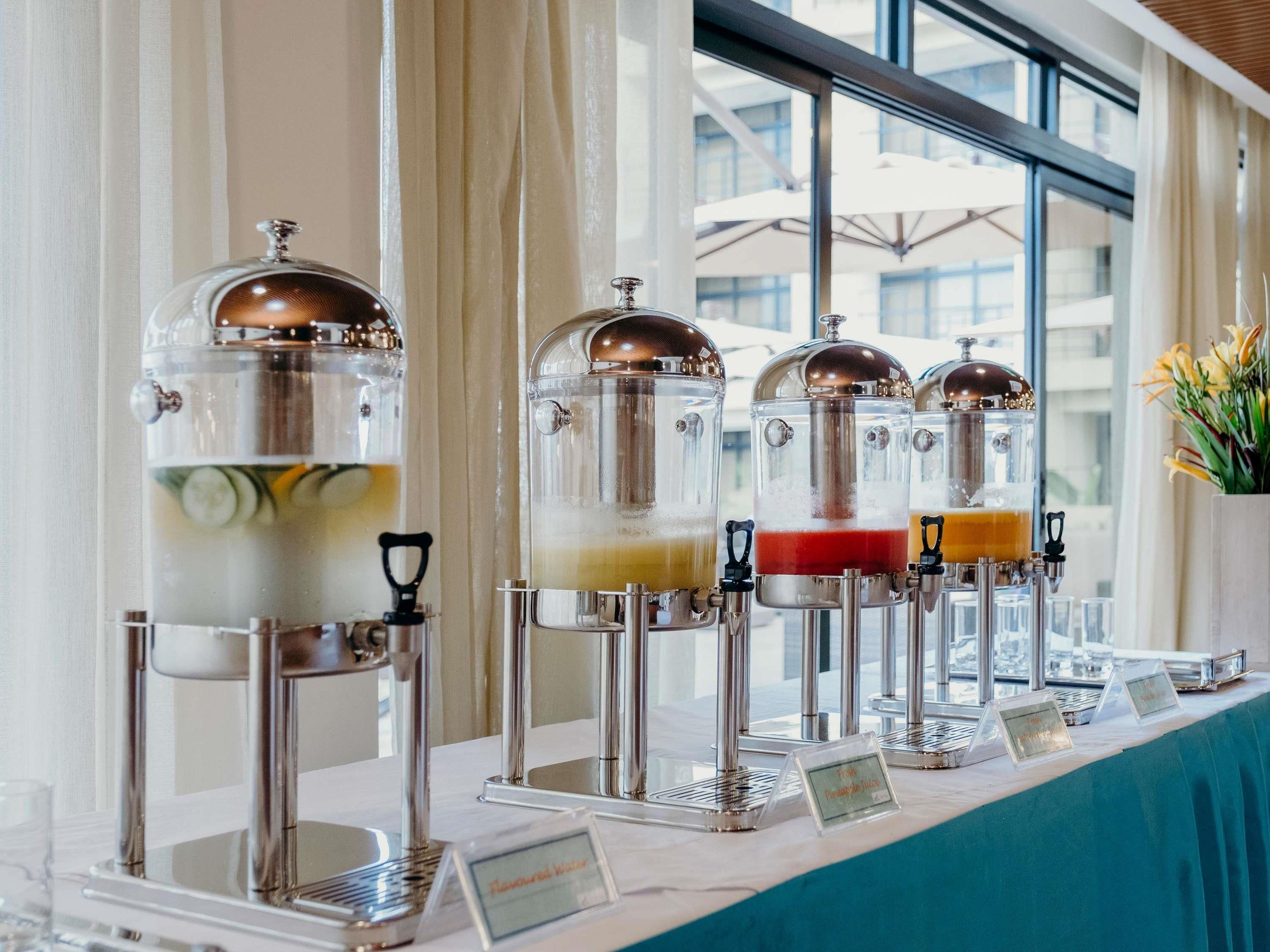 A beverage station with multiple dispensers, each labeled with different drink options.