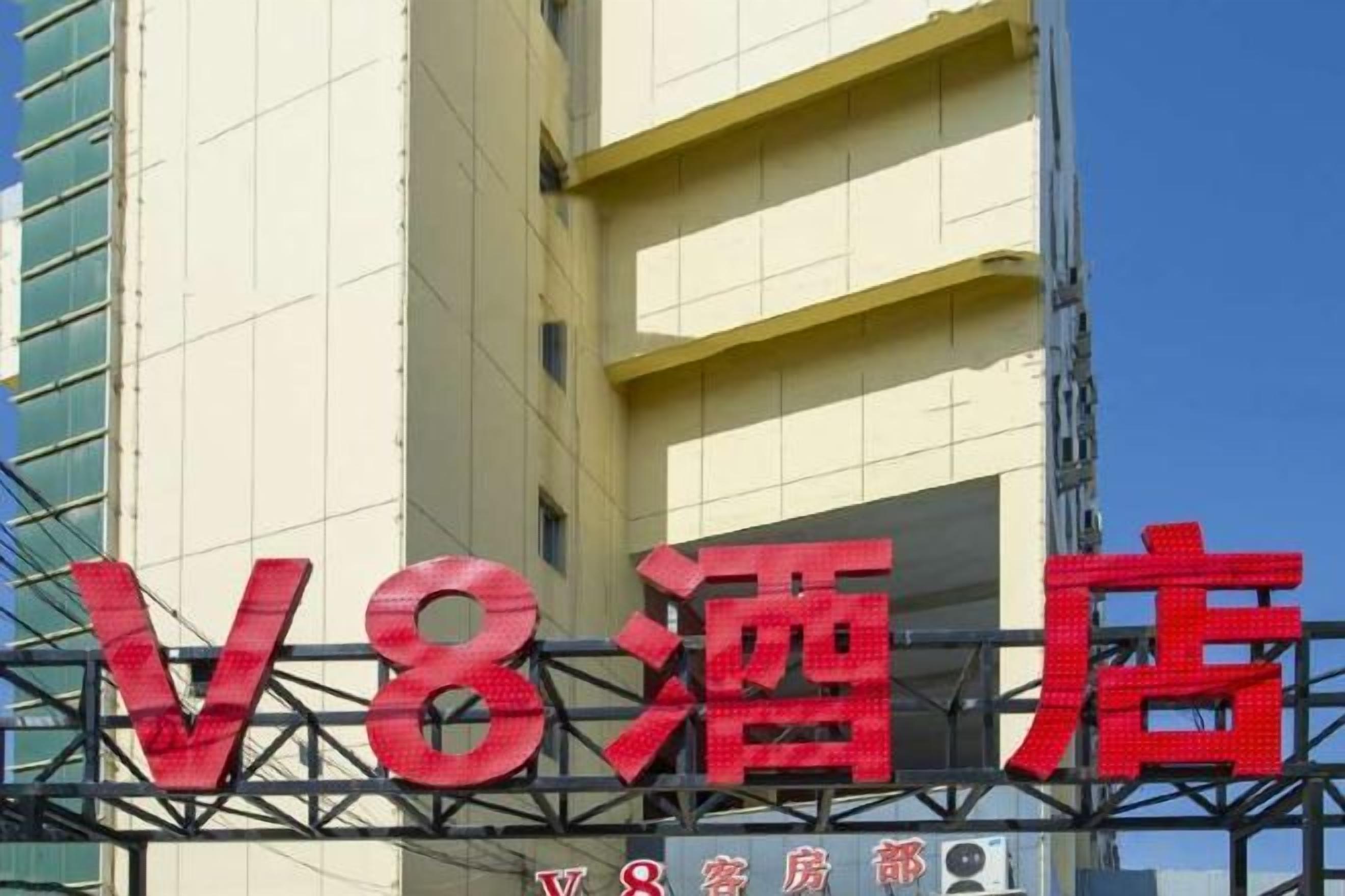 A hotel sign with large red letters and a construction crane in the background.