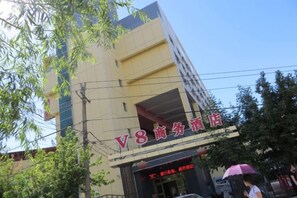 A building with a sign that reads 'V8 Commercial Hotel'. - Yining V8 Business Hotel (Teachers University) (Yining City)