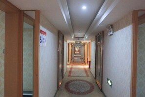 A hotel hallway with carpeted floors, doors on both sides, and a sign indicating room number 5. - Yining V8 Business Hotel (Teachers University) (Yining City)