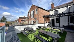 A rooftop terrace with picnic tables and a pergola. - King Suite close to Manchester City Centre, R3 (Stockport)