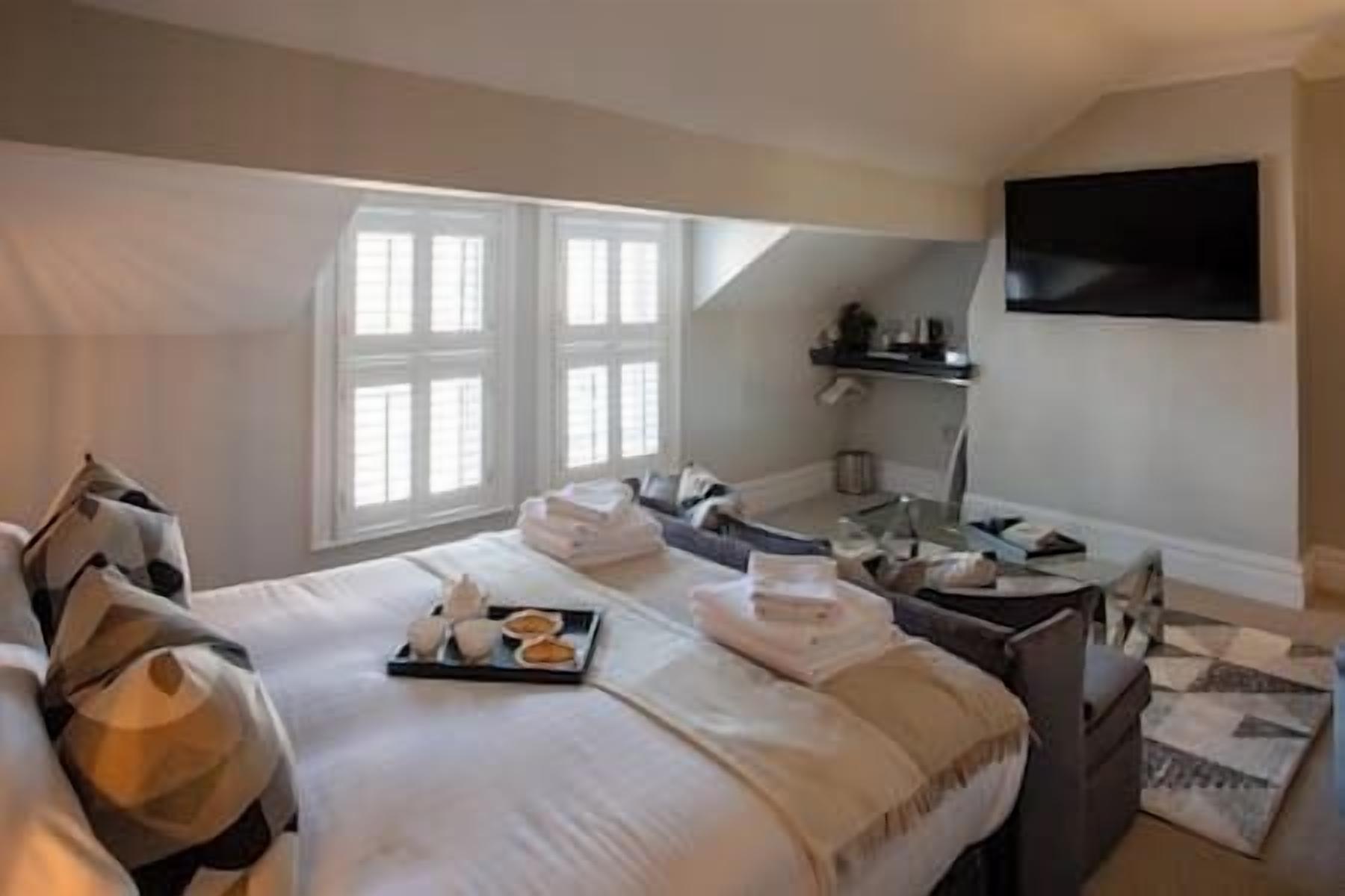 Une chambre d’hôtel avec un grand lit, un bureau et un téléviseur fixé au mur.