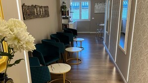 A hallway with teal chairs, round tables, and a yellow table with ornate legs. - Luxurious apartment, close to the center (Roma)