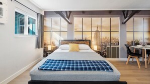 A modern hotel room with a large bed, a dining area, and a cityscape view through large windows. - Cozy studio in awesome Fort Lauderdale with WiFi and parking (Fort Lauderdale)