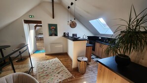 A loft-style apartment with a kitchen, dining area, and a living room. - Chambre Frida Kalho (Laval)