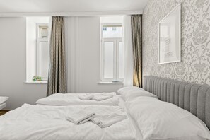 A hotel room with a large bed, a window with curtains, a radiator, and a framed picture on the wall. - Faraway Studios 43 (Vienna)