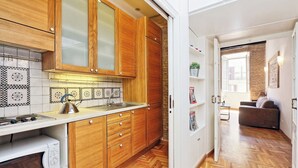 A modern kitchen with wooden cabinets, a microwave, and a stove. - Spagna Charme - One Bedroom Apartment, Sleeps 4 (Rome)