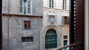 Une rue étroite bordée d’immeubles aux portes en arc de cercle et aux volets traditionnels.