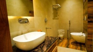 A modern bathroom with a large oval sink, a separate pedestal sink, a shower, and a vanity with a marble countertop. - Familia Hotel and Banquets (Lucknow)