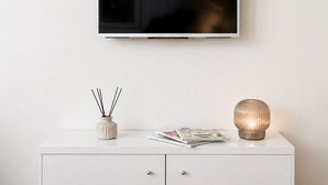 Ein weißes TV-Möbel mit einem flachbildfernseher darüber.