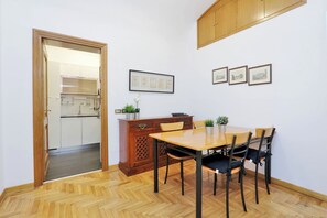 Un comedor con una mesa y sillas de madera, un aparador con adornos y cuadros en la pared.