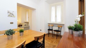 A dining area with a wooden table, four chairs, and potted plants. - Cozy Oppio - One Bedroom Apartment, Sleeps 4 (Rome)