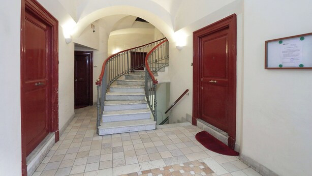 A staircase with a red handrail, white walls, and a tiled floor. - Cozy Oppio - One Bedroom Apartment, Sleeps 4 (Rome)