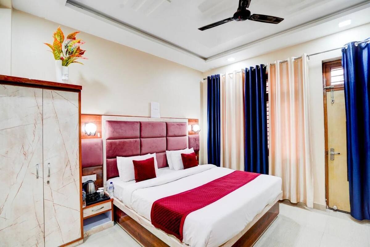 A hotel room with a large bed, a wardrobe, a bedside table, and a ceiling fan.