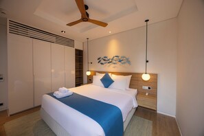 A modern hotel room with a large bed, a ceiling fan, a wall-mounted artwork, and a built-in wardrobe. - Sailing Pool Villas & Resort Phu Quoc (Phu Quoc)