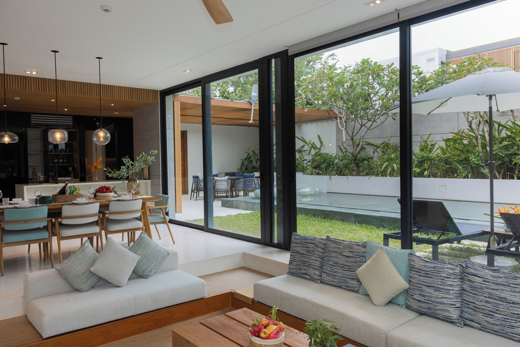 A modern interior with a dining area, seating, and a view of the outdoors.