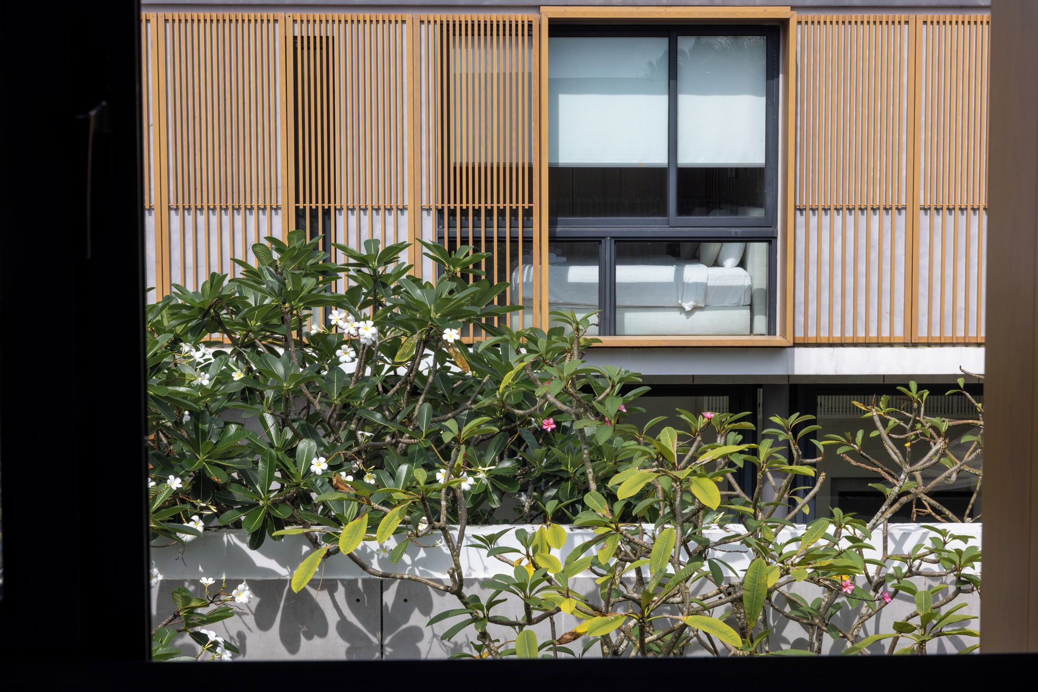 A modern building with a large window and a view of a white sofa inside.