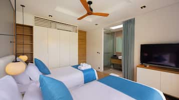 A hotel room with a bed, a television, a ceiling fan, and a bathroom visible through an open door.