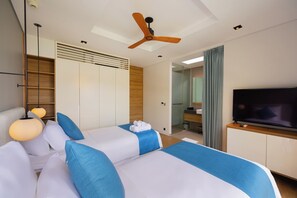 A hotel room with a bed, a television, a ceiling fan, and a bathroom visible through an open door.