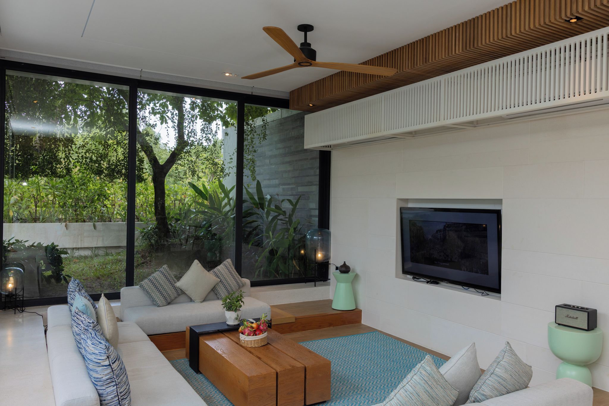 Una sala de estar moderna con un sofá, una mesa de centro y un televisor.