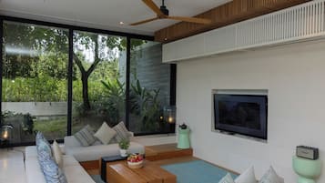 Una sala de estar moderna con un sofá, una mesa de centro y un televisor.
