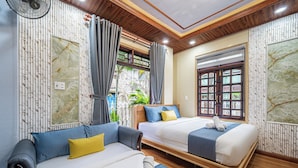 A hotel room with two beds, a sitting area, and a window with curtains. - Cozrum - Cozy Home Phú Yên (Tuy Hoa)