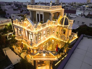 Un edificio lujoso con arquitectura ornamentada, ventanas amplias y un patio espacioso.