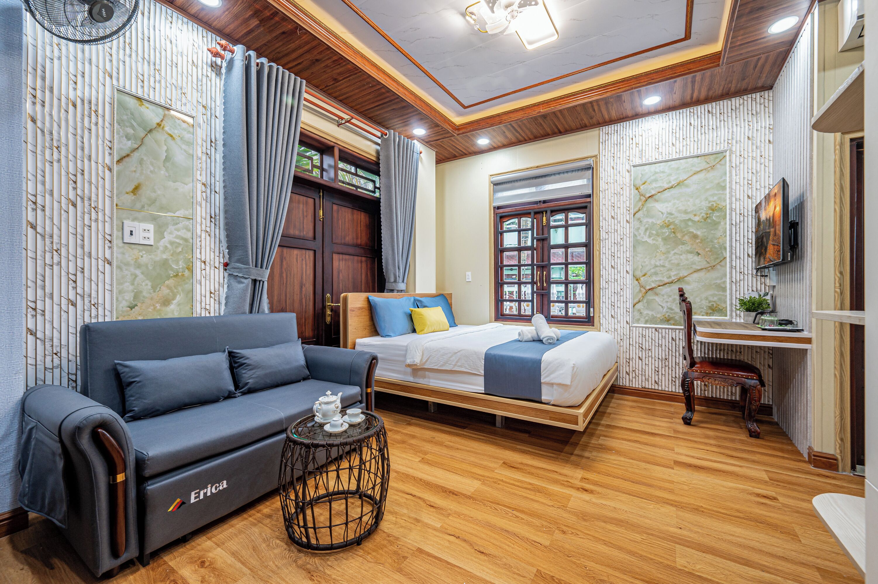 Una moderna camera d'albergo con un divano, un letto, un tavolino e un pavimento in legno.