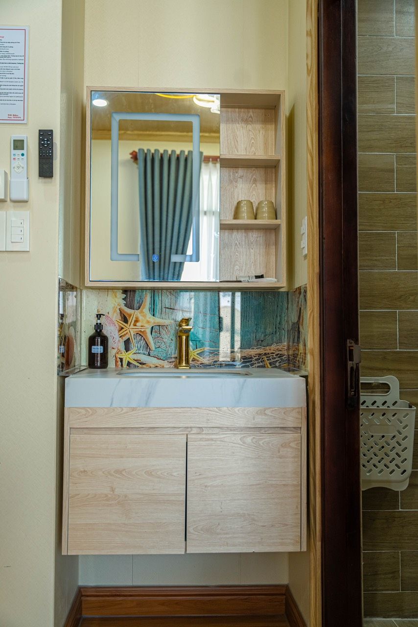 Un baño con tocador de madera, espejo y perchero.