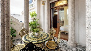A luxurious outdoor seating area with ornate gold and black furniture, a central round table, and a potted plant. - Cozrum - Cozy Home Phú Yên (Tuy Hoa)