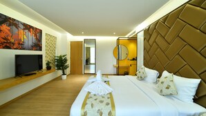 Une chambre d’hôtel avec un grand lit, un téléviseur à écran plat, une plante en pot et un miroir au mur.