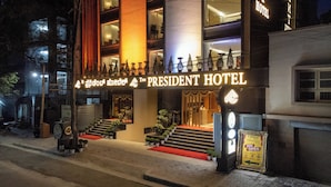 La façade de l’hôtel The President, avec son panneau indicateur, les marches menant à l’entrée et un tapis rouge.