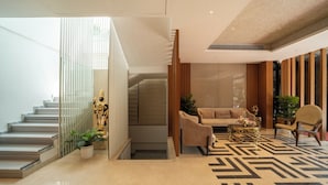 Un hall d’entrée moderne avec un escalier, un canapé, une table basse et un fauteuil.