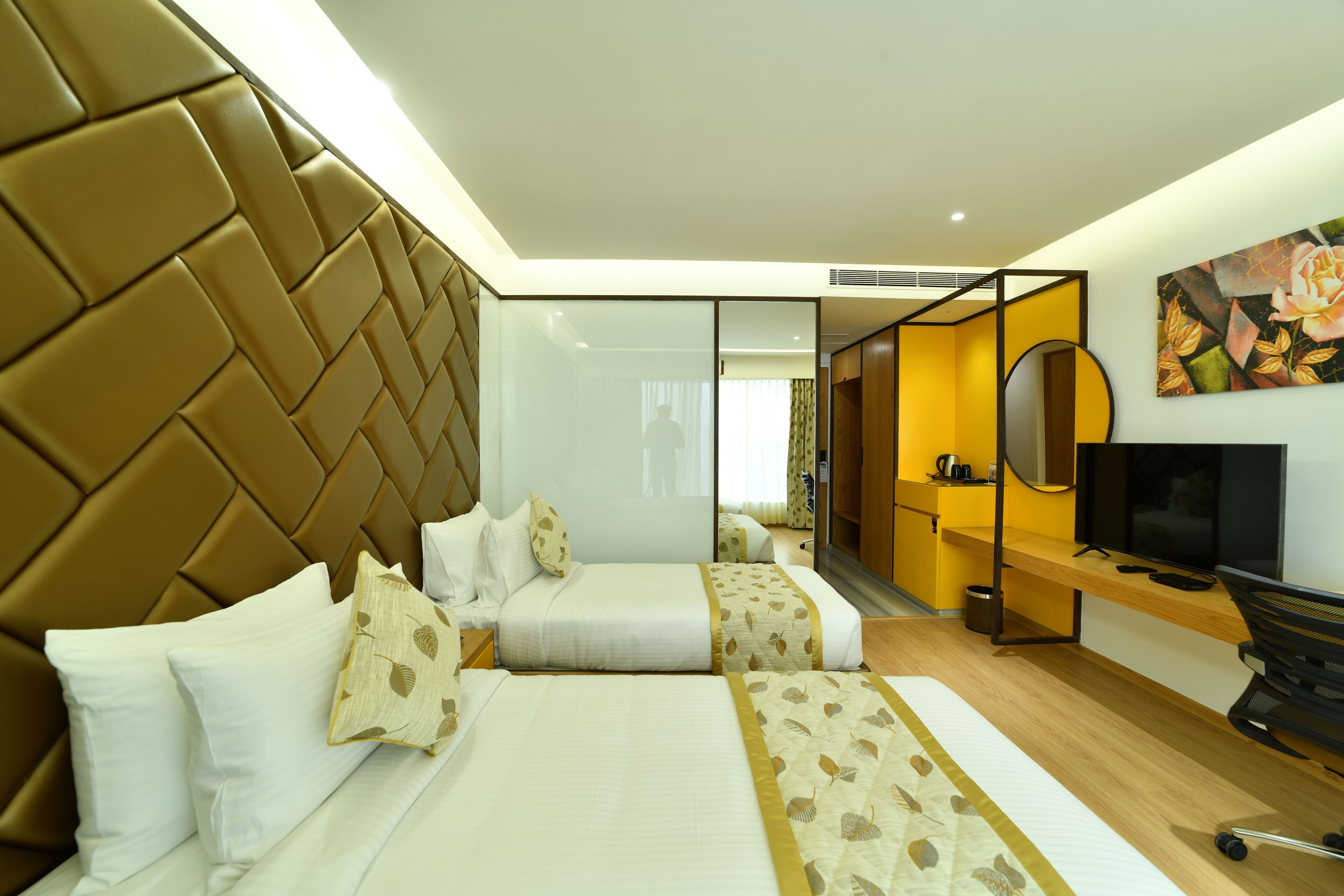 Una habitación de hotel con una cama grande, un escritorio, un televisor y un espejo.