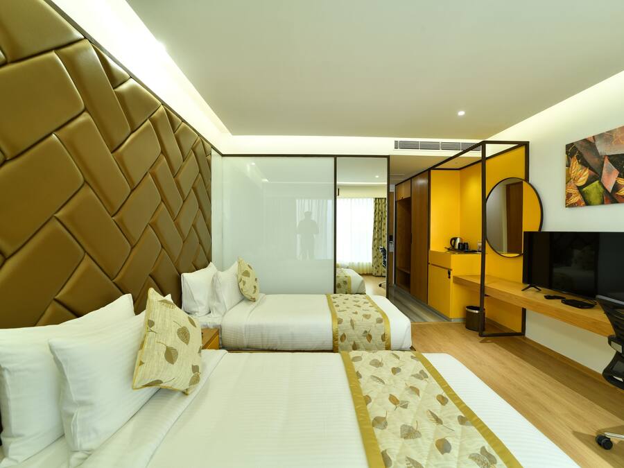 Una habitación de hotel con una cama grande, un escritorio, un televisor y un espejo.