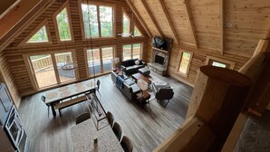 Un loft spacieux avec de hauts plafonds, de grandes fenêtres, une cheminée et un coin repas.