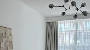 Une chambre à coucher moderne avec un lit, un canapé et une grande fenêtre.