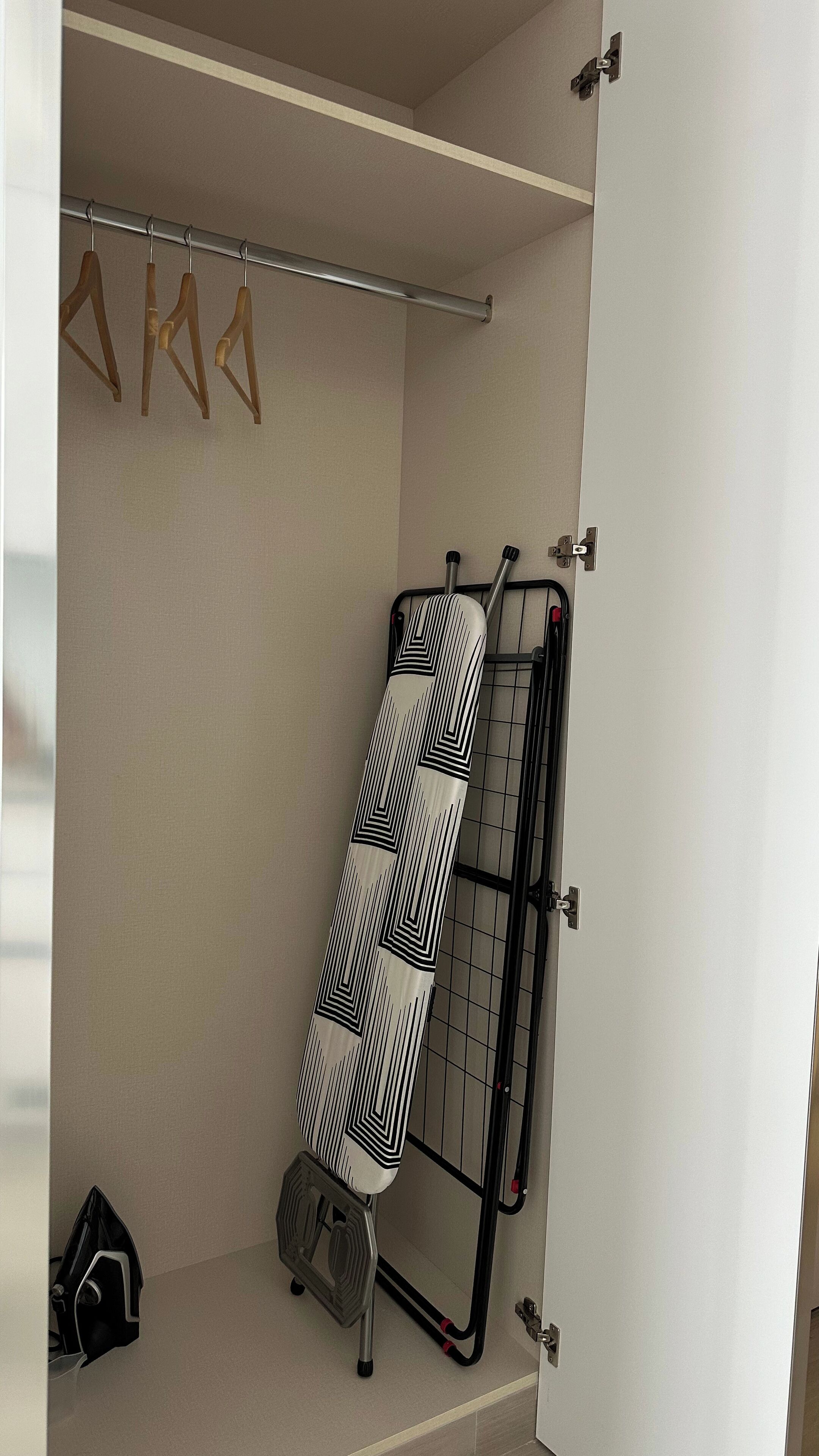 A neatly organized closet with hanging space, a shoe rack, and a storage unit.