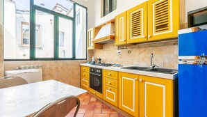 A kitchen with yellow cabinets, a stove, and a sink. - Ghibellina Loft in Firenze (Florence)