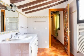 Une salle de bain avec un lavabo, un miroir et des murs carrelés.