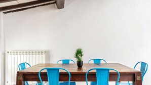 A wooden dining table with six blue chairs, a potted plant, and a white radiator. - Ghibellina Loft in Firenze (Florence)